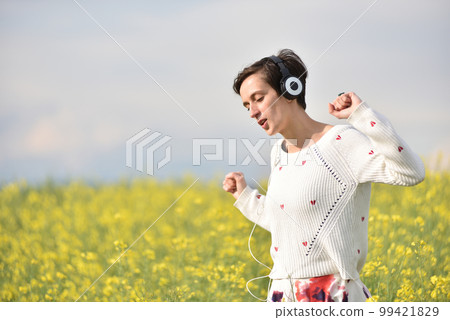 Sexy young woman with headphones dancing in the outdoors 99421829