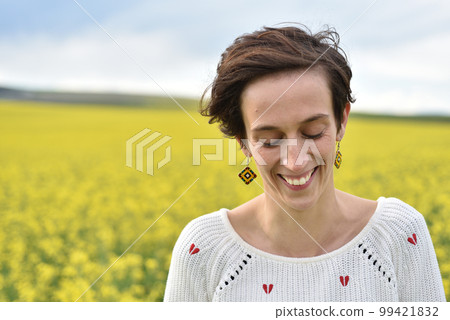 Young woman feeling happy in the middle of a canola field 99421832