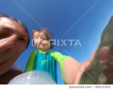 Underwater view of a father and her daughter with distorted faces having fun at the sea Underwater view of a father and her daughter with distorted faces having fun at the sea 99421920