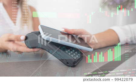Close-up of a woman paying with a smartphone. Stock charts on a virtual screen. Close-up of a woman paying with a smartphone. Stock charts on a virtual screen. 99422079