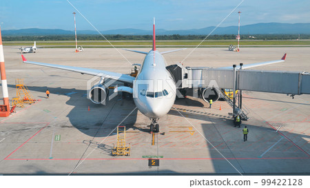 The plane at the airport is waiting for departure at the terminal. 99422128
