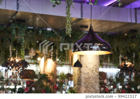 The concept of the interior in the restaurant. A round lamp in an iron frame, suspended from the ceiling and illuminated with gold. With a space to copy. High quality photo The concept of the interior in the restaurant. A round lamp in an iron frame, suspended from the ceiling and illuminated with gold. With a space to copy. High quality photo 99422317