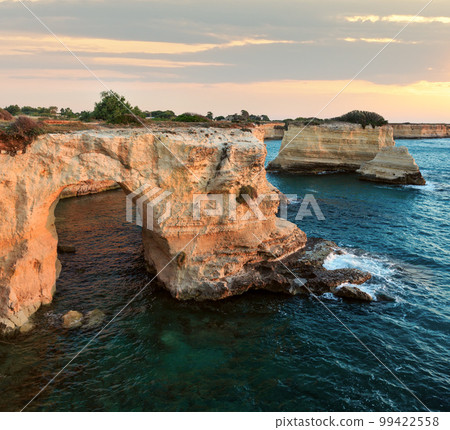 Sunrise seascape with cliffs, rocky arch and stacks (faraglioni), at Torre Sant Andrea, Salento sea coast, Puglia, Italy Sunrise seascape with cliffs, rocky arch and stacks (faraglioni), at Torre Sant Andrea, Salento sea coast, Puglia, Italy 99422558
