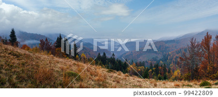 Cloudy and foggy early morning autumn mountains scene. Peaceful picturesque traveling, seasonal, nature and countryside beauty concept scene. Carpathian Mountains, Ukraine. 99422809