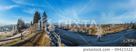 Winter coming. Last days of autumn, morning in mountain countryside peaceful picturesque hoarfrosted scene. Dirty road from hills to the village. Ukraine, Carpathian mountains. 99423322