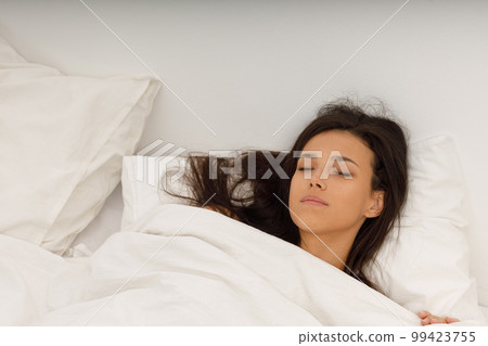 Healthy young woman covering white blanket sleep in bed at bedroom. 99423755