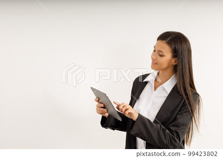 Portrait of successful business woman with tablet in her hands, dressed in white shirt and black jacket on isolated white background. Studio shot of attractive brunette girl Portrait of successful business woman with tablet in her hands, dressed in white shirt and black jacket on isolated white background. Studio shot of attractive brunette girl 99423802