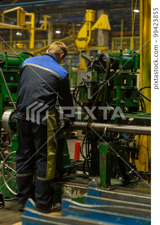Worker on workplace of an employee of a plant for the production of cardan shafts. Worker on workplace of an employee of a plant for the production of cardan shafts. 99423855
