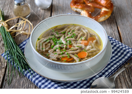 Bavarian, Swabian and Austrian dish - liver spaetzle in a beef soup served with a crispy pretzel Bavarian, Swabian and Austrian dish - liver spaetzle in a beef soup served with a crispy pretzel 99424589
