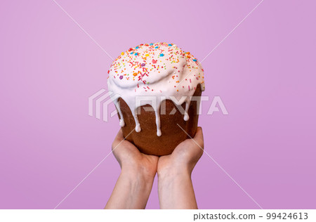 Easter holiday sweet bread kulich on hands on pink Easter holiday sweet bread kulich on hands on pink 99424613