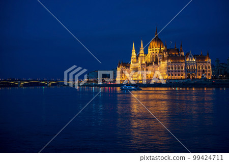 Illuminated Hungarian Parliament building and Margit Hid, Margaret Bridge night-time view with reflection in Danube river, Budapest, Hungary. Illuminated Hungarian Parliament building and Margit Hid, Margaret Bridge night-time view with reflection in Danube river, Budapest, Hungary. 99424711