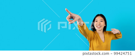 Excited asian woman pointing at copy space for advertisement, web-banner Excited asian woman pointing at copy space for advertisement, web-banner 99424751