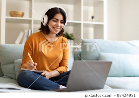 Young Arab Woman In Headset Study Online With Laptop From Home Young Arab Woman In Headset Study Online With Laptop From Home 99424951