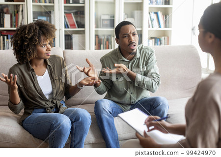 Emotional black spouses fighting in front of family therapist Emotional black spouses fighting in front of family therapist 99424970