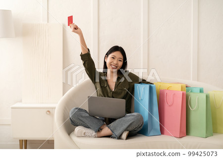 Happy young asian woman shopaholic shopping from home Happy young asian woman shopaholic shopping from home 99425073