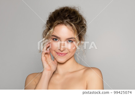 Portrait of sensual beautiful young woman posing on grey studio background, enjoying her smooth glow face skin 99425074
