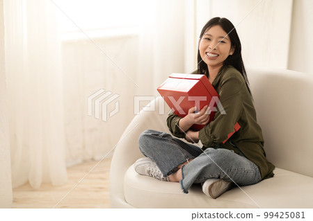 Overjoyed asian woman customer receive good parcel, home interior Overjoyed asian woman customer receive good parcel, home interior 99425081