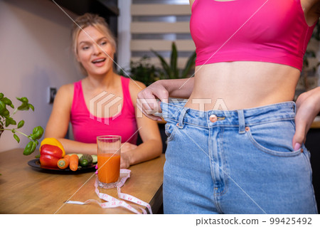 Two women in sporty pink tops at a health food table Two women in sporty pink tops at a health food table 99425492