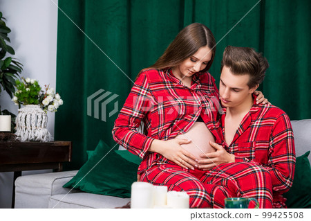 girl sits on the lap of her boyfriend, who touches her pregnant belly girl sits on the lap of her boyfriend, who touches her pregnant belly 99425508