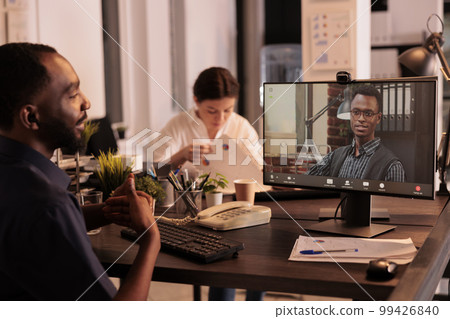Remote coworkers talking on corporate videocall on computer, employees discussing company strategy on online business meeting. Team leader listening to colleague on videoconference Remote coworkers talking on corporate videocall on computer, employees discussing company strategy on online business meeting. Team leader listening to colleague on videoconference 99426840