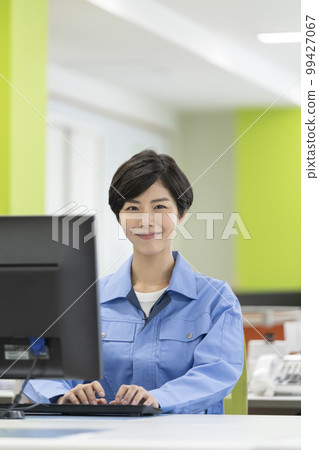 案頭工作,穿著工作服的年輕女性,看著鏡頭,微笑 案頭工作,穿著工作服的年輕女性,看著鏡頭,微笑 99427067