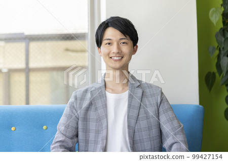 Portrait of a young man smiling looking at the camera Portrait of a young man smiling looking at the camera 99427154
