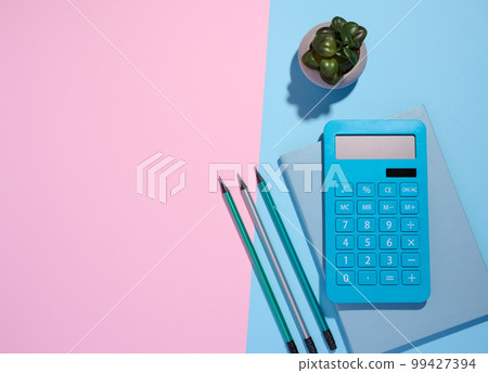 Blue notepad, calculator and wooden pencil on a blue background, top view 99427394