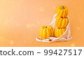 Different varieties of Pumpkins in mesh bag of fabric on orange background.Composition of pumpkins.Happy Thanksgiving.Vegetable fall food concept.Autumn Halloween Pumpkins.Autumn concept.Copy space. 99427517