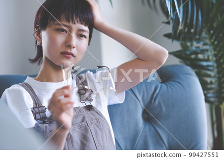Woman sitting on the couch Woman sitting on the couch 99427551