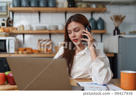 Asian Business woman working at kitchen room at home office and analyze financial report document. Accounting and Finance concept. 99427936