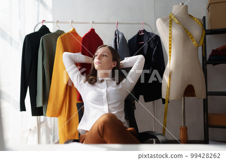 Beautiful young professional stylist working at design studio interior. fashion designer concept 99428262