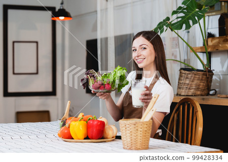 Young Healthy woman cooking healthy food in the kitchen at home. Healthy lifestyle, food, diet concept. 99428334