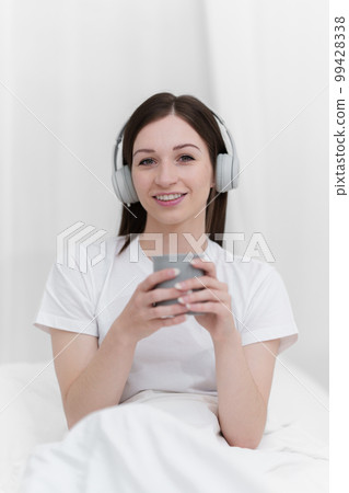 Portrait of Good Healthy woman drinking tea and resting in bed at bedroom. Lifestyle at home concept 99428338