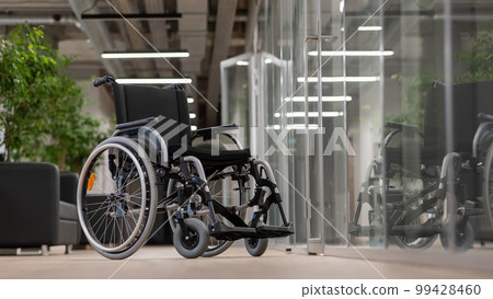 Empty wheelchair in the hallway in the office.  99428460