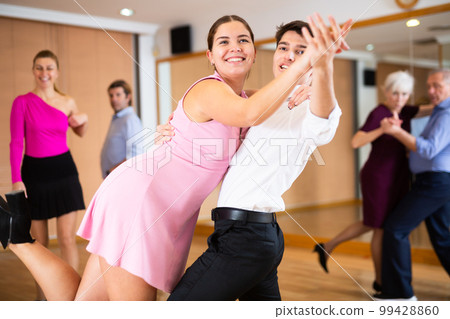 Young couple enjoying impassioned merengue in latin dance class 99428860