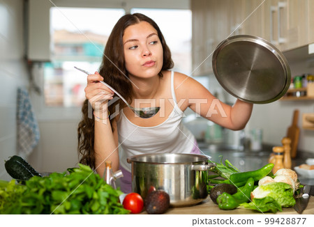 Woman holding cooking pot on kitchen 99428877