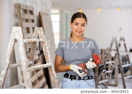 Portrait of a contented young woman with a screwdriver in hands Portrait of a contented young woman with a screwdriver in hands 99428951