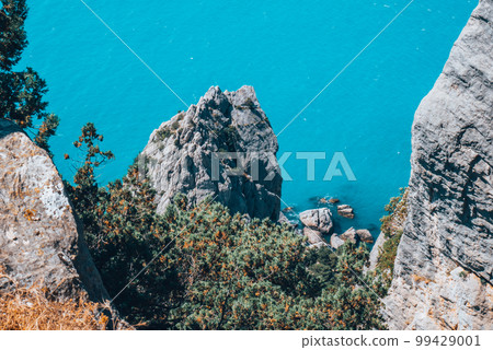 A high sheer cliff, beautiful blue sea and sky. 99429001