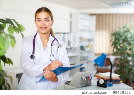Female doctor standing in hall of clinic Female doctor standing in hall of clinic 99429132