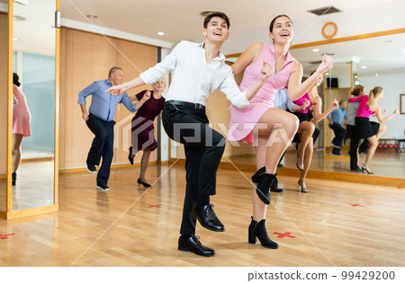 Young happy couple performing a paired dance in ballroom 99429200