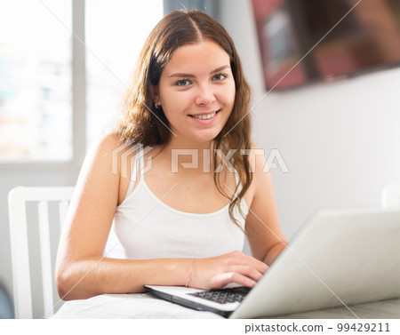 Young woman working on laptop at home Young woman working on laptop at home 99429211