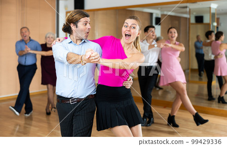 Cheerful man and woman practicing ballroom dances in ballroom 99429336