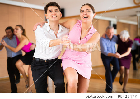 Young pair practicing Latino dance in dance studio Young pair practicing Latino dance in dance studio 99429477