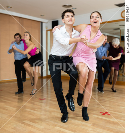 Young happy couple performing a paired dance in ballroom 99429484