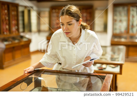 Young woman with information booklet visiting museum Young woman with information booklet visiting museum 99429521