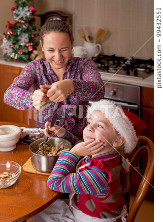 Christmas atmosphere. Children drink tea. Depps have prepared Christmas cookies and have fun in the kitchen at their home Christmas atmosphere. Children drink tea. Depps have prepared Christmas cookies and have fun in the kitchen at their home 99432551