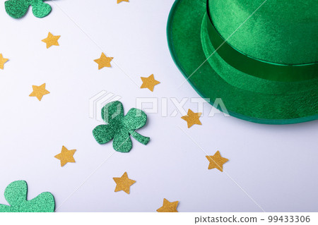 Green hat, golden stars and shamrocks decorations with copy space on white background 99433306