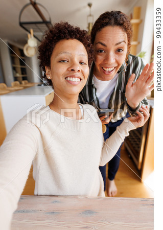Happy diverse lesbian couple having video call 99433359