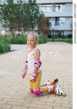 A little girl and her mom do a bridge exercise at the outdoor sports ground.  99433406