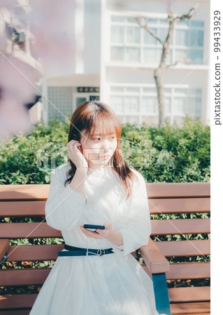 Photo of a young woman listening to music in the park 99433929